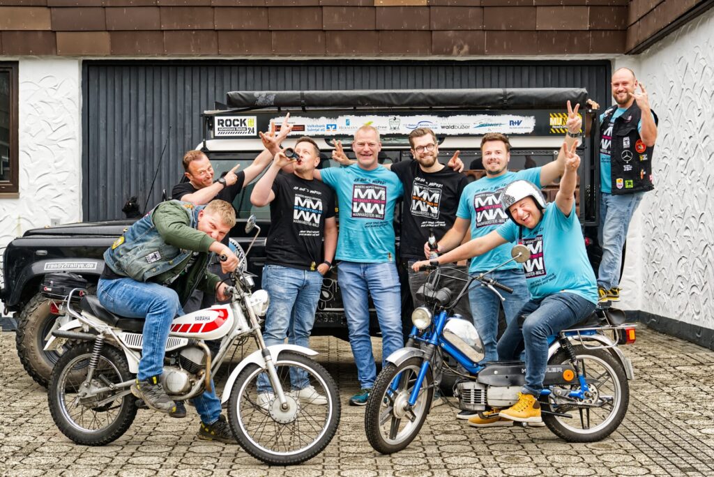 Die Muneros (v.l.n.r): Daniel Dietrich auf seiner Yamaha (Zeugwart im Verein), Thorsten Stark (Organisation und Veranstaltungen), Thomas Pfreundtner (Organisation der Strecken und Koordinator des Quattro M), Christian Burghardt („Chef“ über Essen und Getränke beim Mopedevent), Sebastian Krämer (Sponsoring und Werbung), Michael Hermann (Kassier), Ralf Oppenländer (Moderator beim Quattro M und Presseverantwortlicher) auf seiner Kreidler Flory, Jonas Oppenländer (Charitybeauftragter) stehend auf seinem Land Rover.