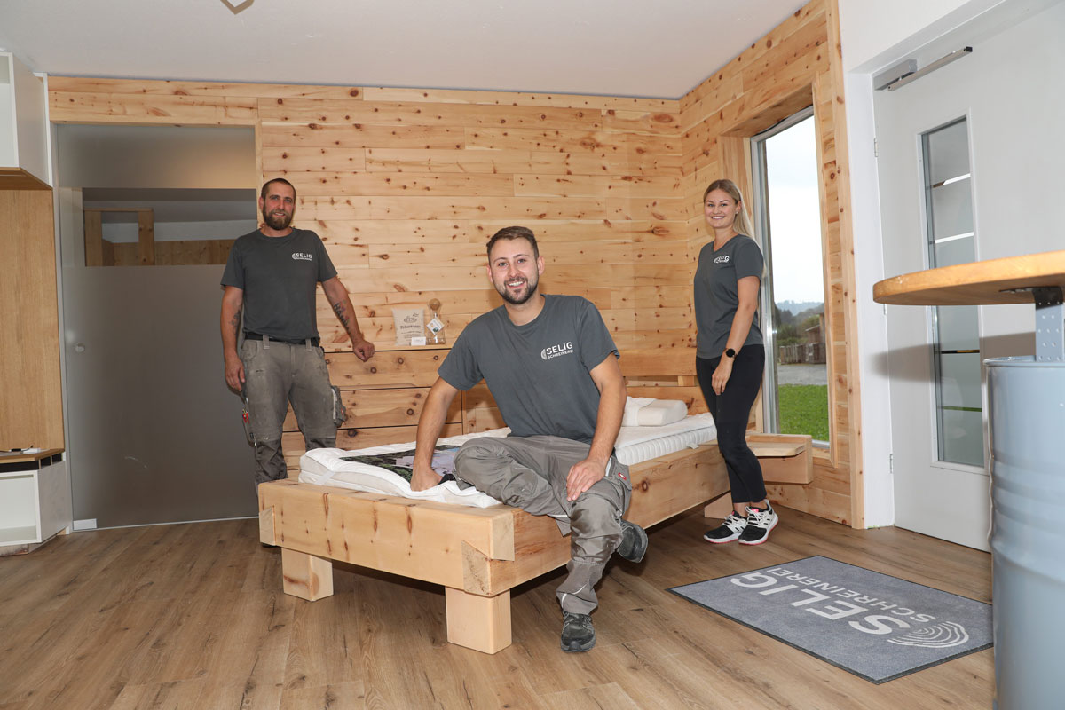 Schreinermeister Lars Selig (Mitte) und sein Team präsentieren ein handgefertigtes Bett aus herrlich duftendem Zirbenholz. Foto: Metzger